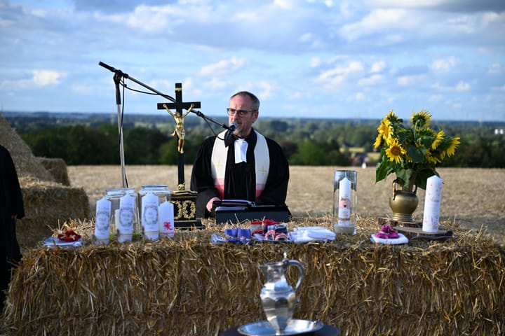 Geistlicher am Strohballenaltar beim Open-Air-Gottesdienst auf dem Dielinger Klei